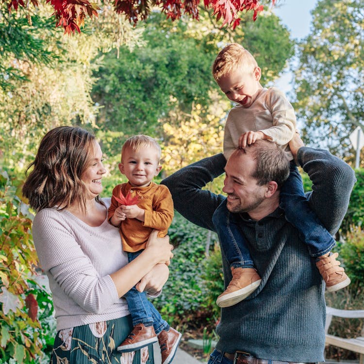 Family with two kids laugh for their free outdoor park photoshoot
