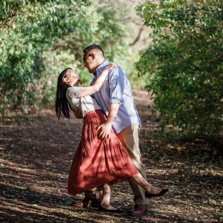 Man dips woman in nature preserve for their free outdoor couple photoshoot