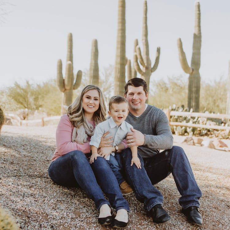 Family poses in front of cactus for their free outdoor family photoshoot
