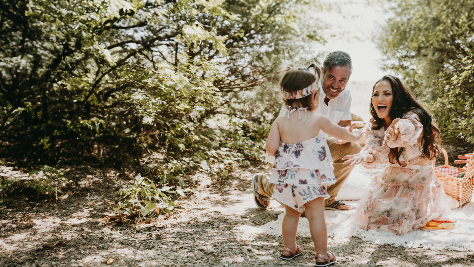 father holding up daughter while daughter touches cherry blossom tree