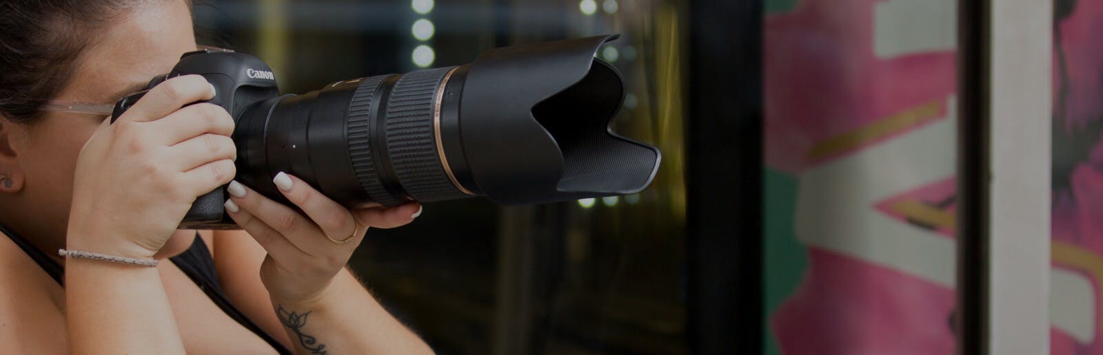 closeup of a photographer looking through her camera lens