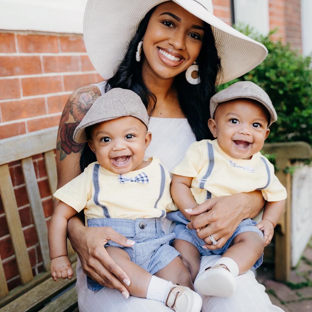 mother with twins sitting a wooden bench
