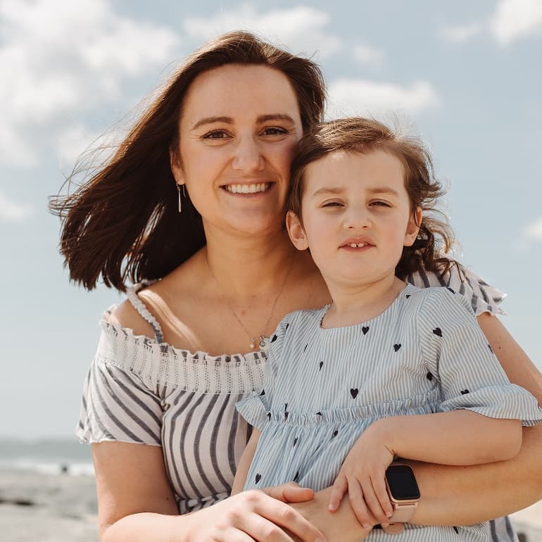 mother posing with a small child on a beach