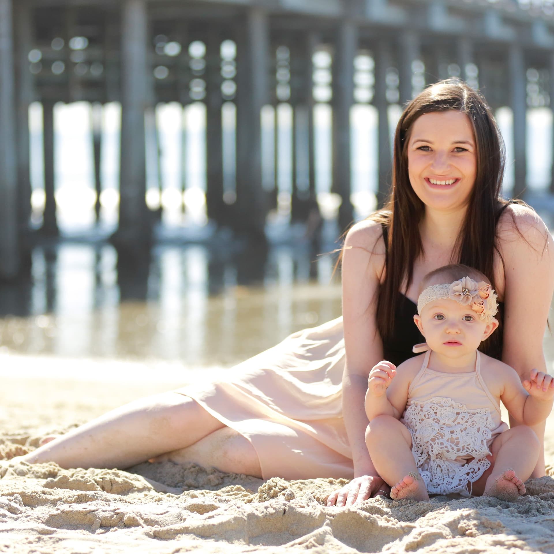 Mother poses with her baby on the beach for her free outdoor beach photoshoot