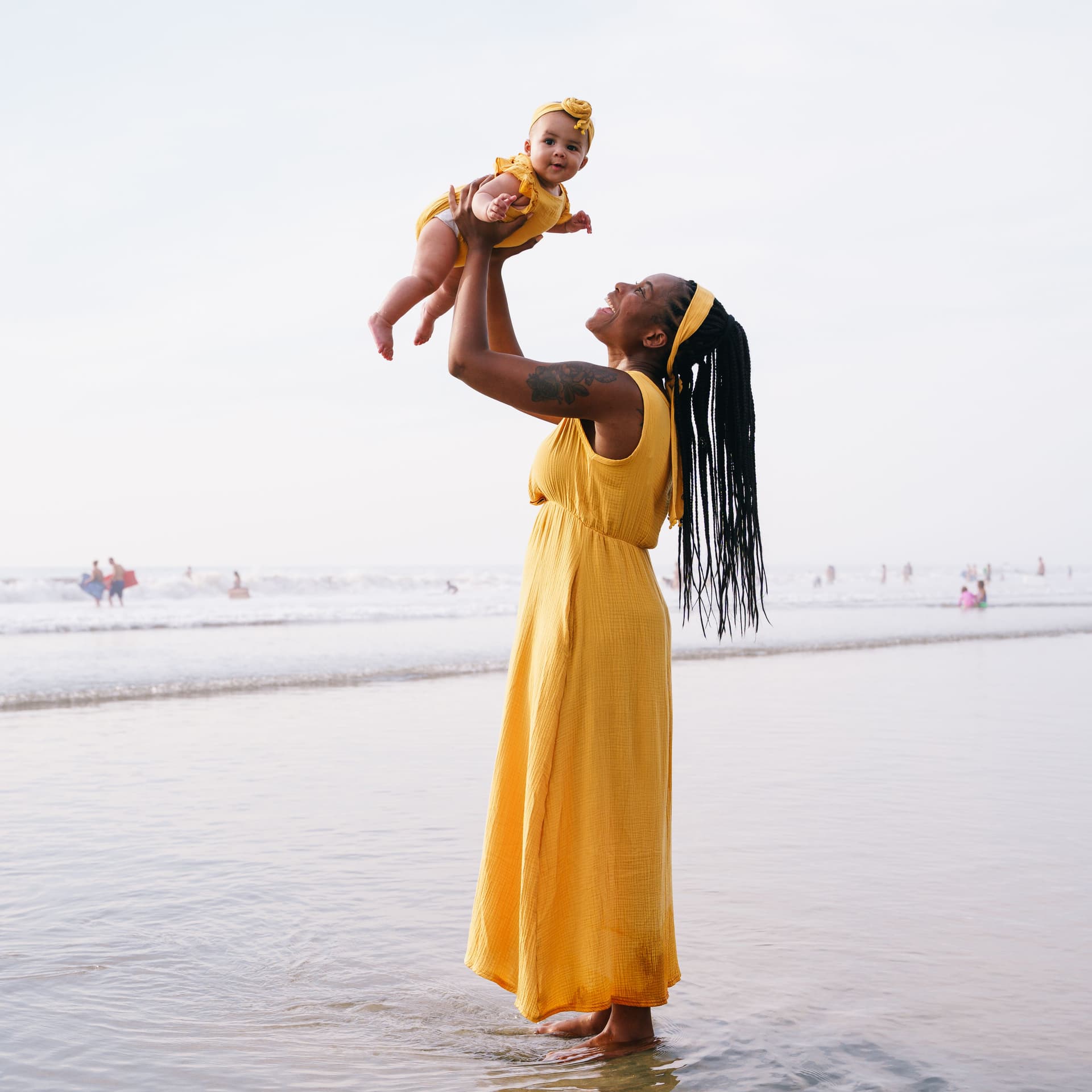 Mother raises her baby for her free outdoor beach photoshoot