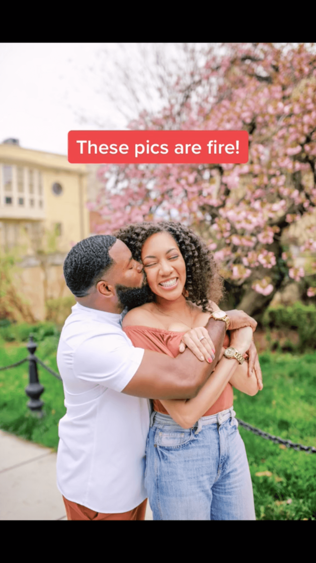 A man kissing a smiling woman on the cheek in front of blossoming trees with text "These pics are fire!" overlayed.