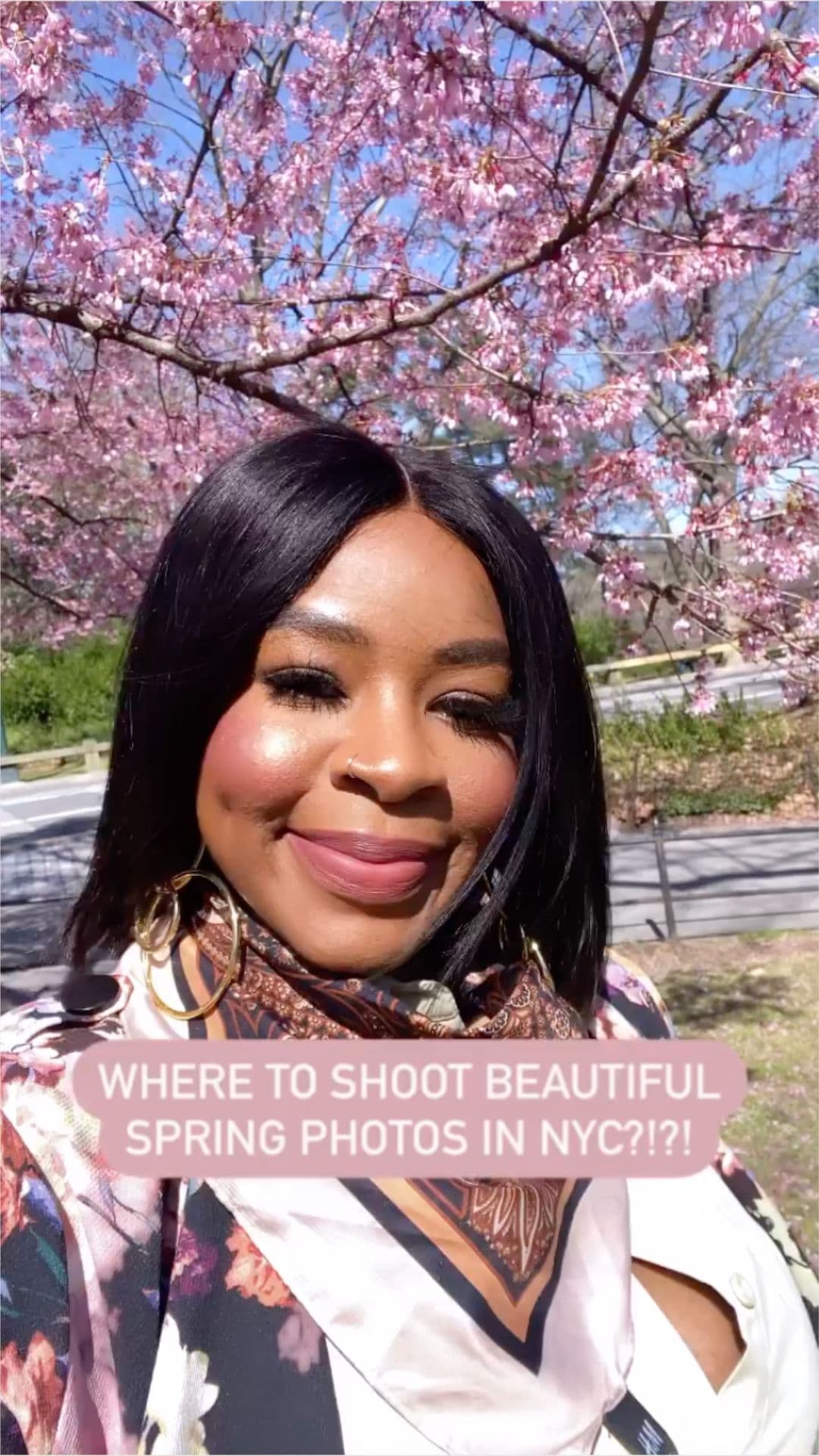 Person smiling for a selfie with cherry blossoms in the background.