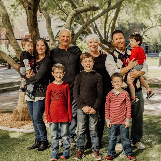 Three-generation family posing together outdoors with children and grandparents