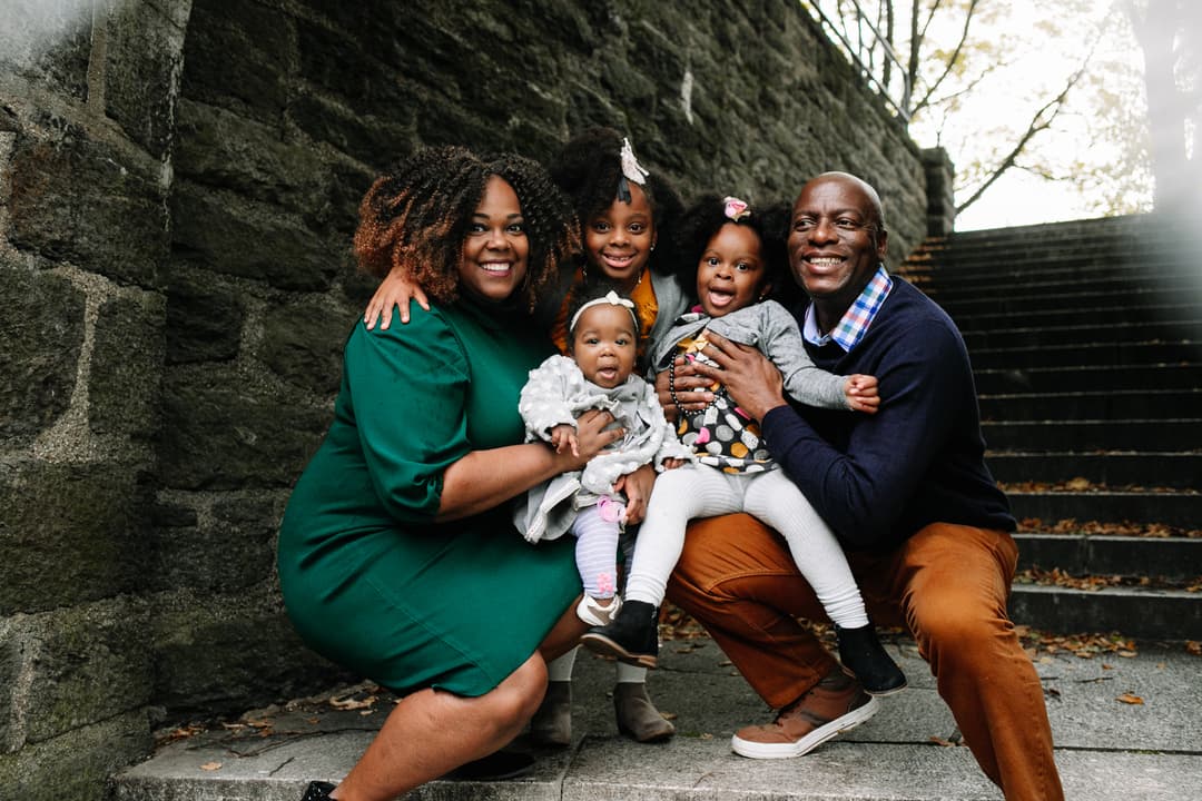 Family of six posing together on stone steps against an ivy-covered wall during a professional Shoott photo shoot.