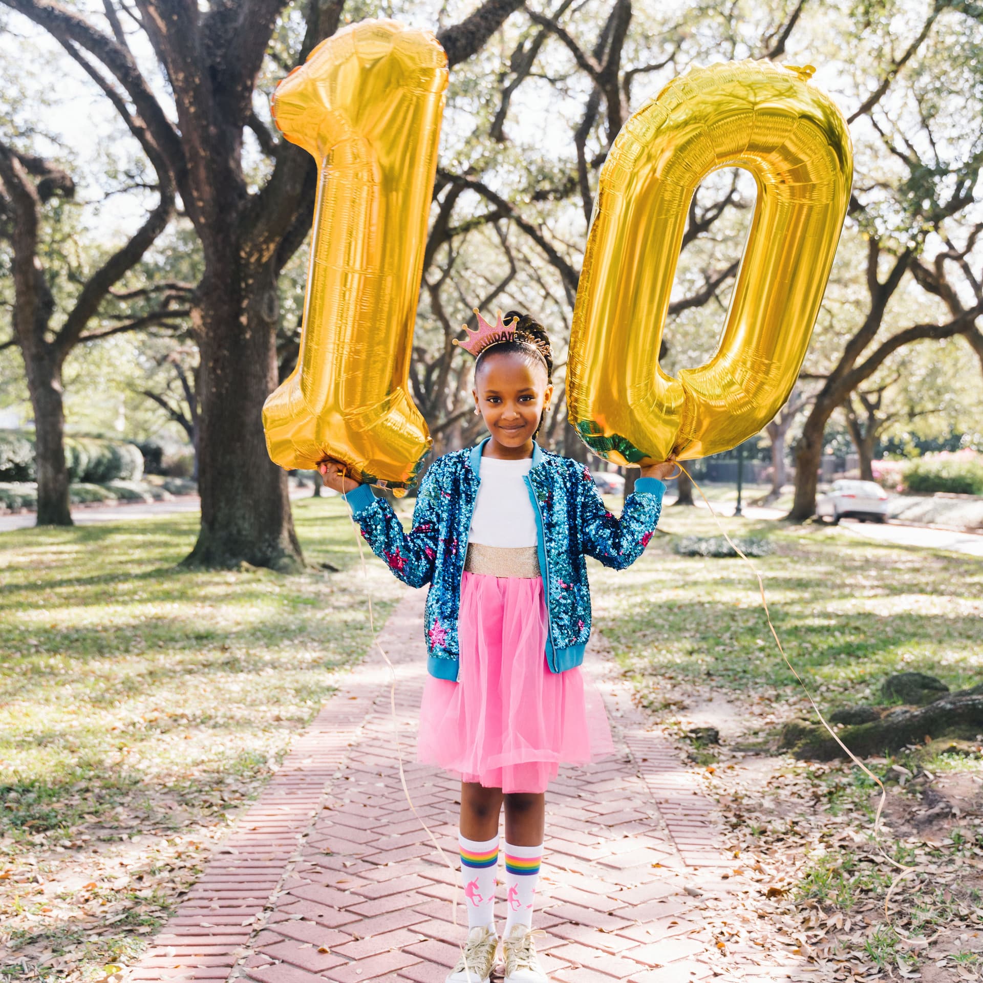 Girl holds number balloons for her free outdoor birthday photoshoot