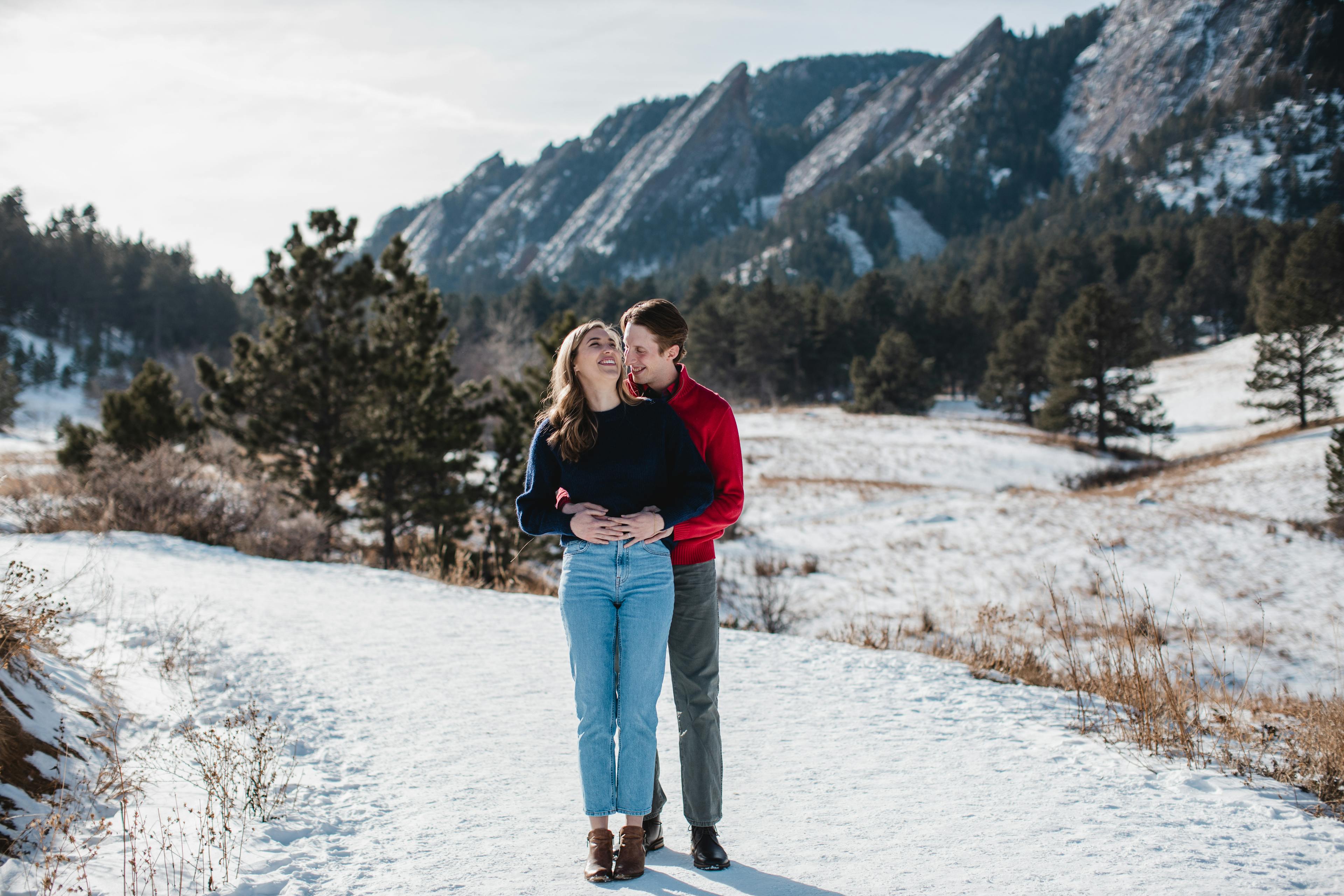 Couple embracing and kissing in a snowy mountainous setting