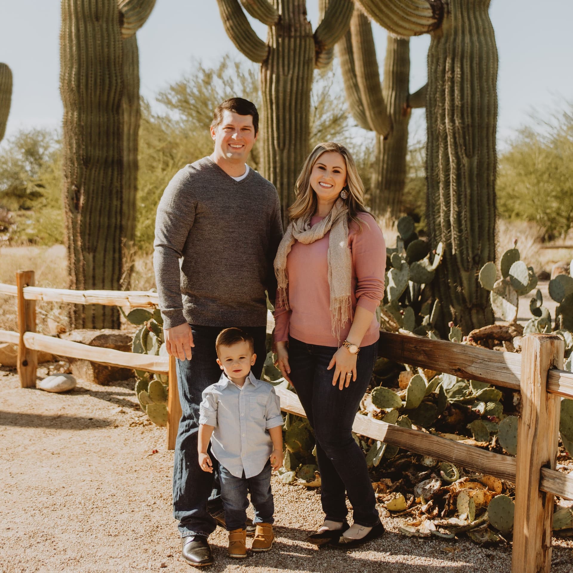 Family poses in front of cactus for their free outdoor family photoshoot