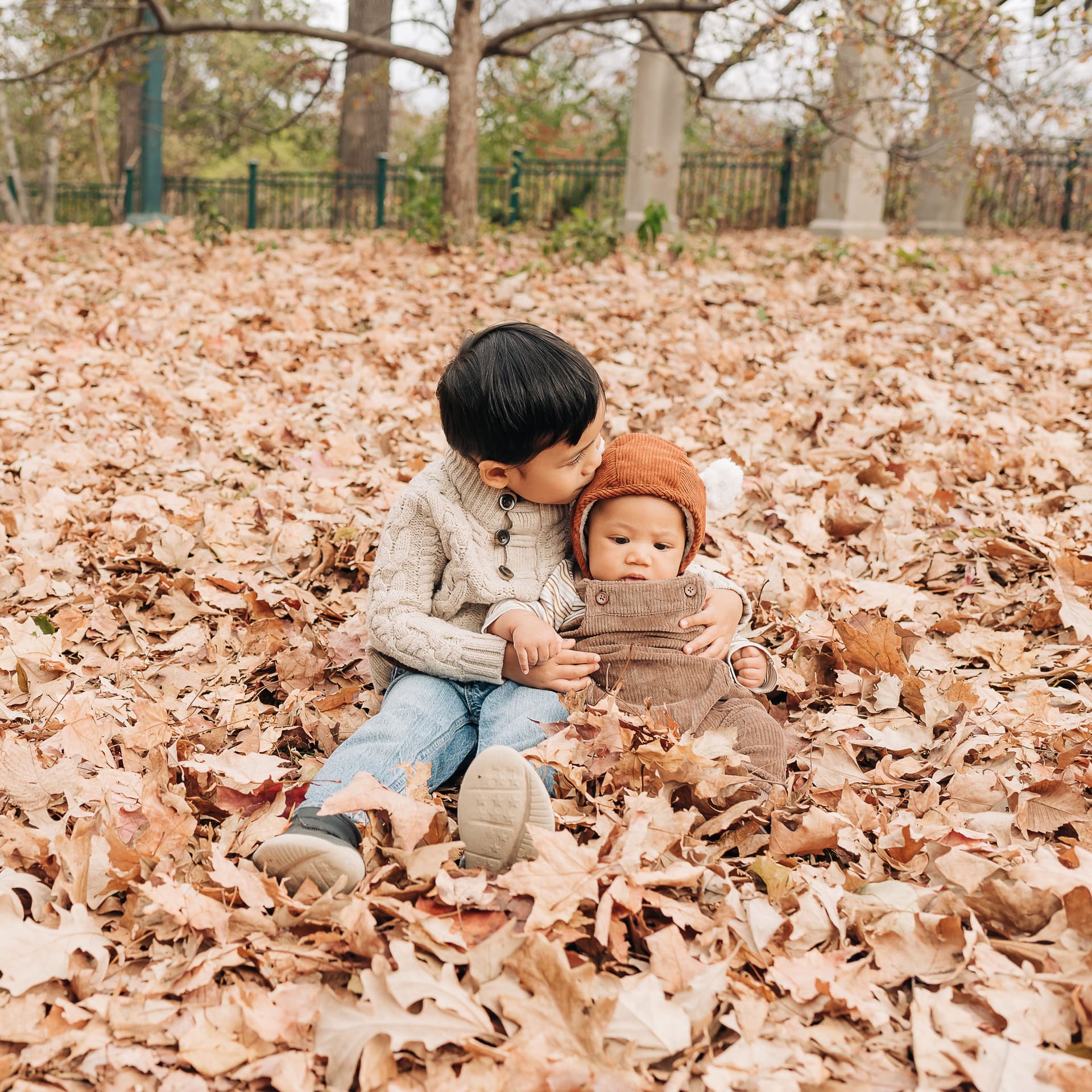 Smiling family throws leaves for their free outdoor fall photoshoot