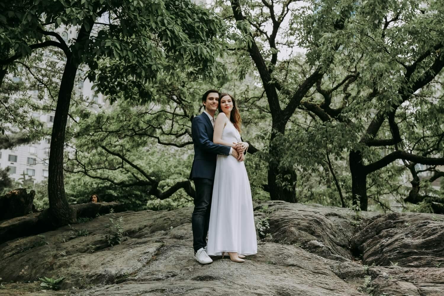 A couple standing together on a rocky outcrop in a park