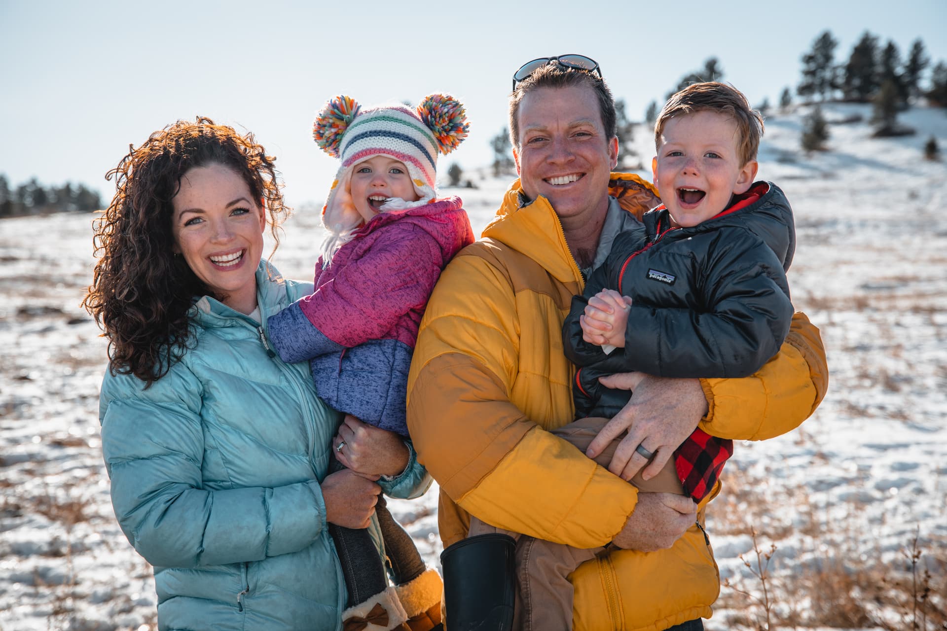 Family with two children smiling in a snowy landscape